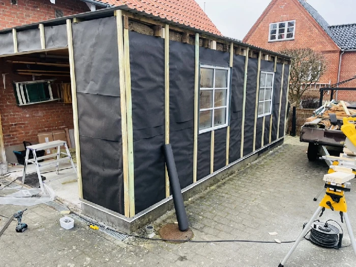 Hus under renovering med glasdøre og ny beklædning